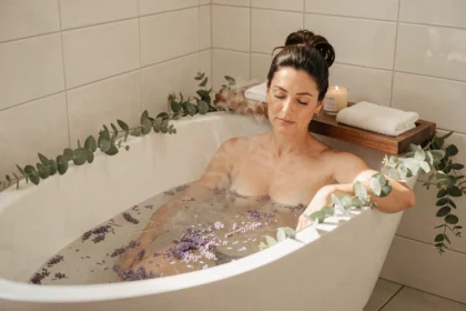 Femme se relaxant dans un bain chaud aux pétales de lavande après une journée de travail